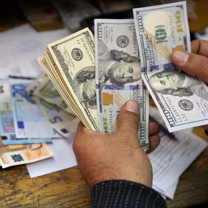 A money changer counts dollar and euro notes