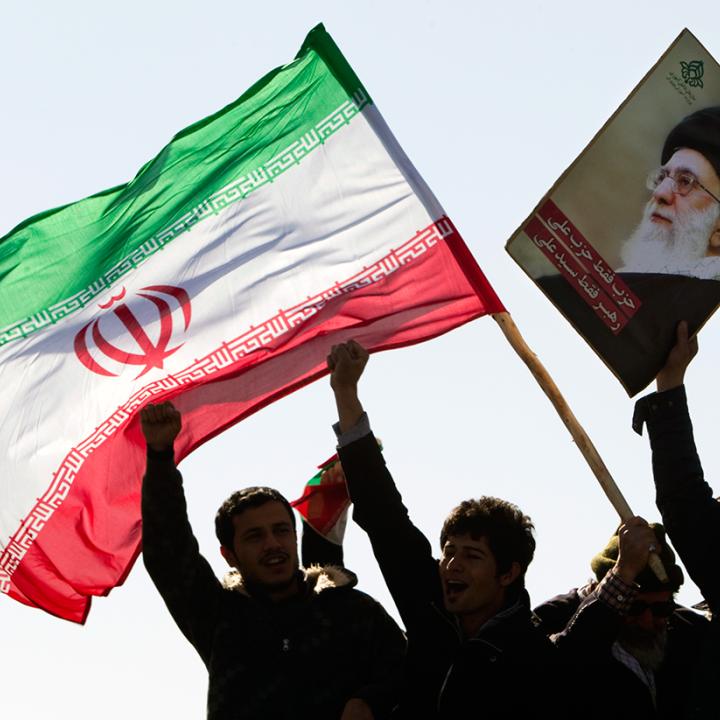 Protesters wave the Iranian flag and a photo of Iran's supreme leader Ali Khamenei