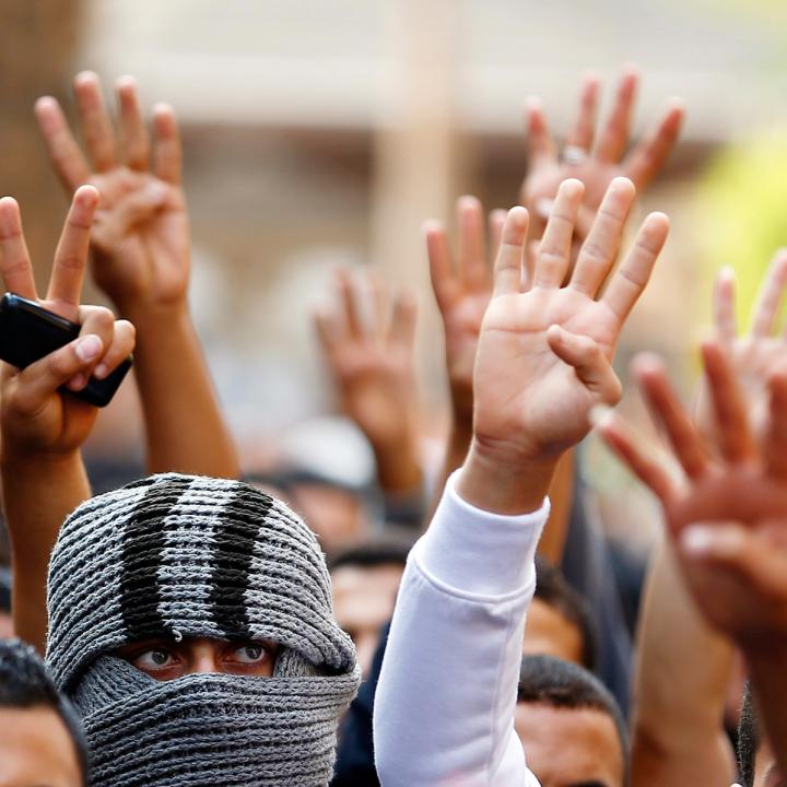 Muslim Brotherhood supporters in Egypt display the victory and Rabaa signs at a protest