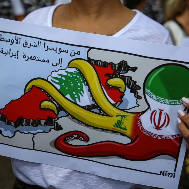 A Lebanese protester holds a sign denouncing Iranian influence