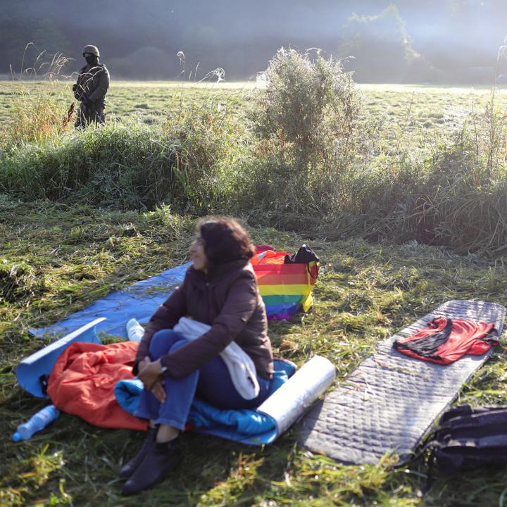 A Middle Eastern migrant with guards at the Belarus/Poland border. Source: Reuters