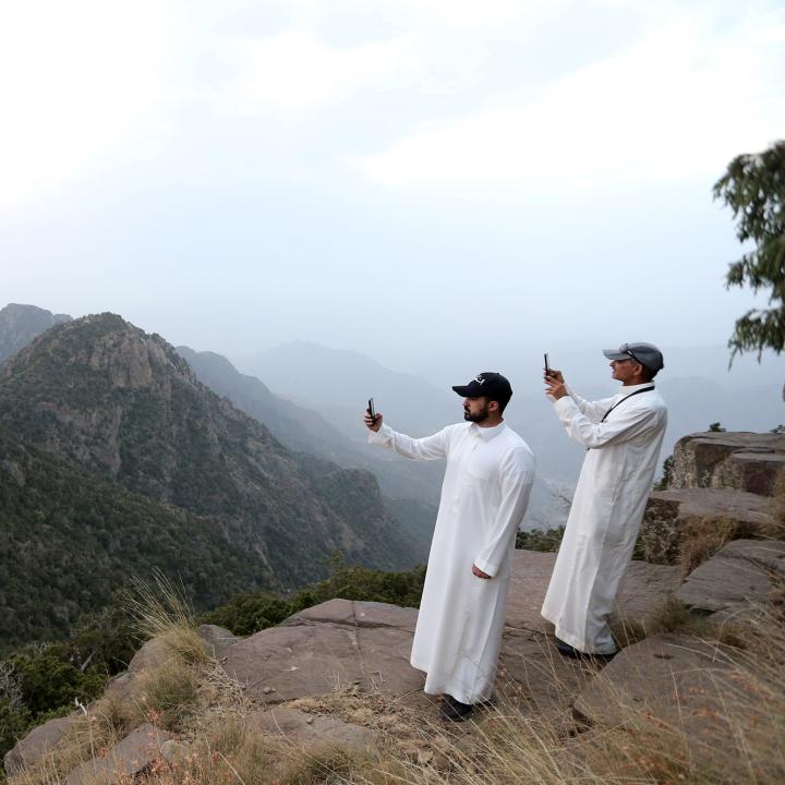 Saudi men take pictures at the Al Souda mountain - source: Reuters