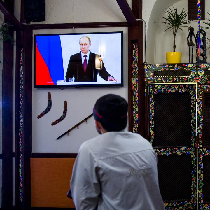 A man watches Russian president Vladimir Putin speak on television in the Crimean city of Simferopol - source: Reuters