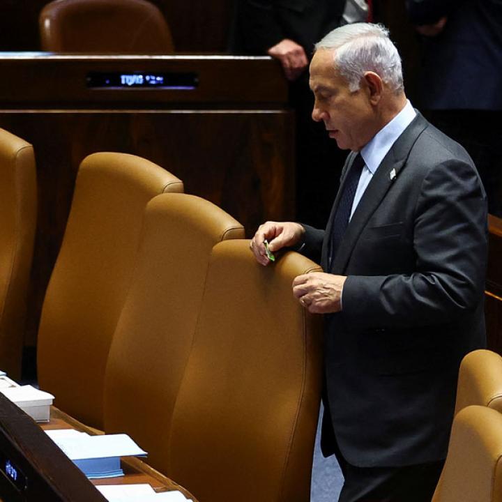 Photo of Israeli prime minister Binyamin Netanyahu standing alone in parliament.