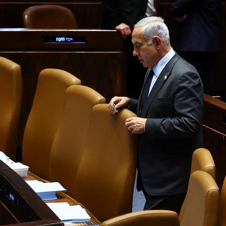 Photo of Israeli prime minister Binyamin Netanyahu standing alone in parliament.