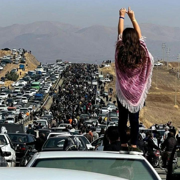 Twitter photo showing an Iranian woman standing on top of a car during a protest against the killing of Mahsa Amini.