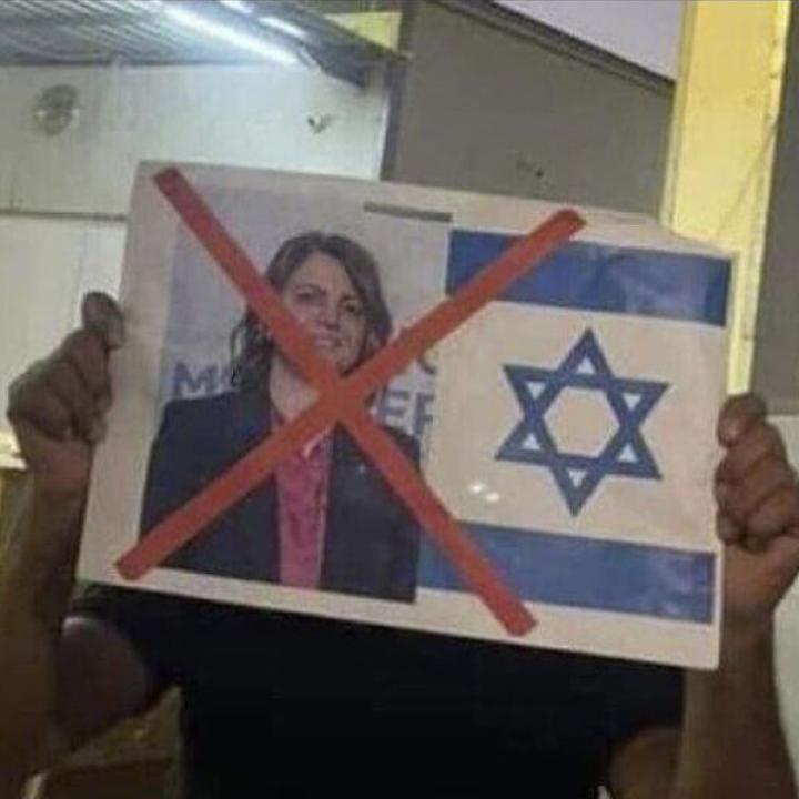 A Libyan protester holds up a sign denouncing Foreign Minister Najla al-Mangoush for meeting with an Israeli official.