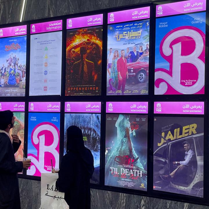Moviegoers look at posters and showtimes at a theater in Riyadh, Saudi Arabia in August 2023, including the global hit "Barbie" - source: Reuters