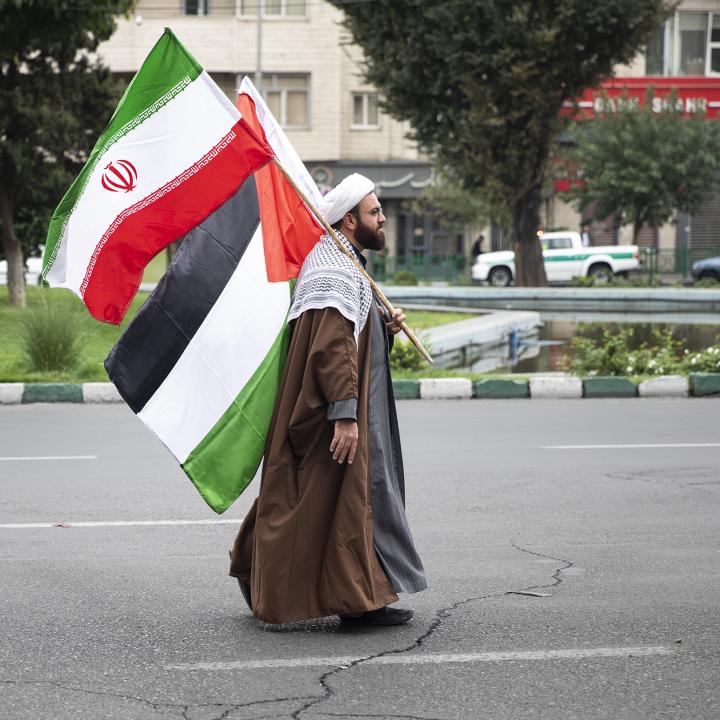 A man carries Iranian and Palestinian flags at a pro-Hamas rally in Tehran in October 2023 - source: Reuters