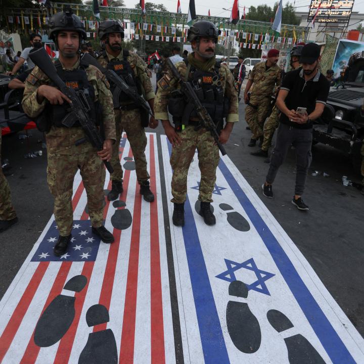 Photo of an October 2023 Iraqi demonstration with footprints covering the Israeli and American flags.