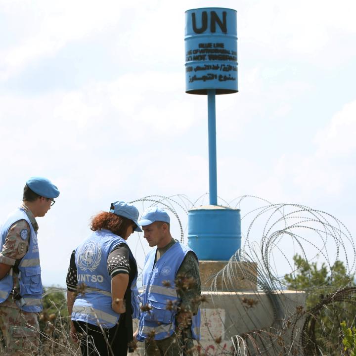 Unarmed UN staff from the United Nations Truce Supervision Organization stand near a Blue Line marker on the Israel-Lebanon borner - source: Reuters