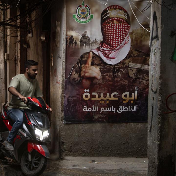 A man rides a scooter by a Hamas poster in a Palestinian refugee camp in Lebanon, May 18, 2024.