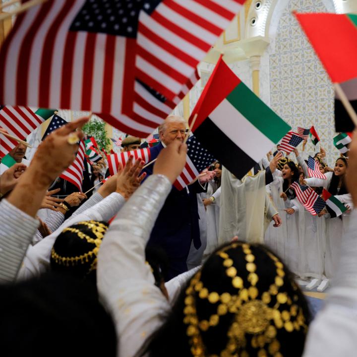 Children wave US and UAE flags during President Trump's May 2025 visit to Abu Dhabi - source: Reuters