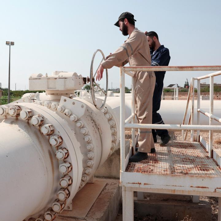 Photo of workers at a natural gas pipeline in Syria.