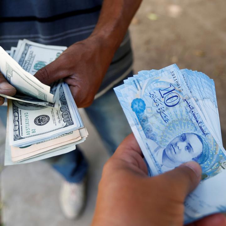 A Tunisian purchases dollars from a money-changer - source: Reuters