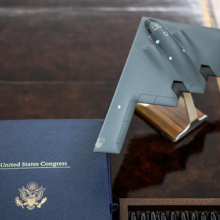 A model of a B-2 stealth bomber sits next to legislation on the president's Oval Office desk - source: The White House