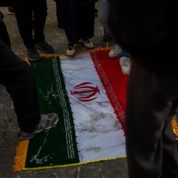 Protesters trample on an Iranian flag - source: Reuters