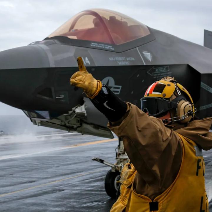 A flight deck crewman directs operations of an F-35 jet on board the USS Abraham Lincoln - source: Department of Defense