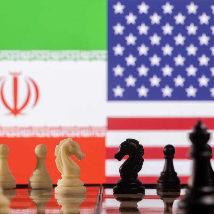 A photo illustration depicts chess pieces and the Iranian and U.S. flags - source: Reuters