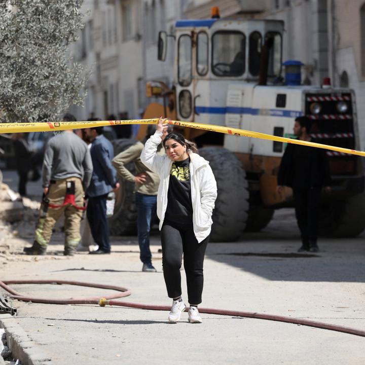 An Iranian woman walks by the scene of a U.S. airstrike in Tehran - source: Reuters