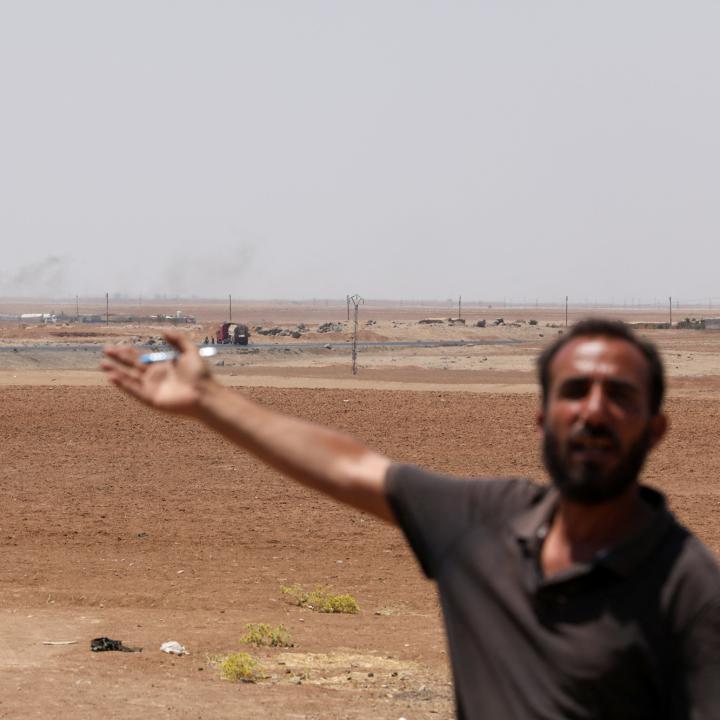 A Syrian man gestures at a makeshift oil refinery - source: Reuters