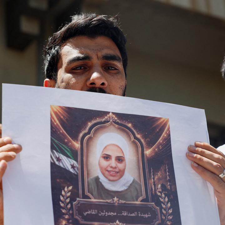 Photo of Syrians holding a memorial protest for family members killed by the former Assad regime.