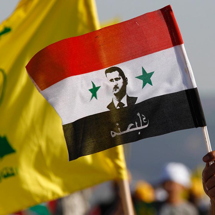 Protesters hold Syrian and Hezbollah flags