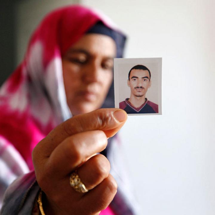 A Tunisian woman holds a photo of a relative who joined a jihadist movement