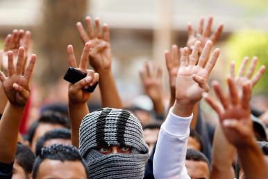 Muslim Brotherhood supporters in Egypt display the victory and Rabaa signs at a protest