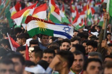 Iraqi Kurds display Kurdish and Israeli flags