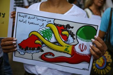 A Lebanese protester holds a sign denouncing Iranian influence