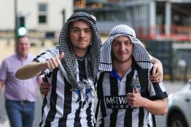 Newcastle United fans celebrate the Saudi purchase of their team