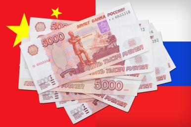 Photo illustration of Russian Ruble banknotes with Chinese and Russian flags - Source:TWI/Reuters