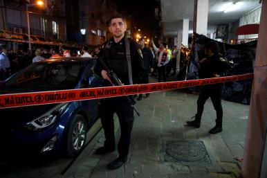 An Israeli security officer stands guard at the scene of a terrorist shooting in Tel Aviv, March 2022.