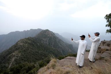 Saudi men take pictures at the Al Souda mountain - source: Reuters
