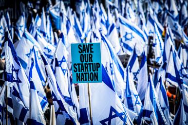 Protesters wave flags and placards in front of the Knesset to demonstrate their opposition to judicial reforms proposed by the coalition government of Israeli Prime Minister Netanyahu - source: Reuters