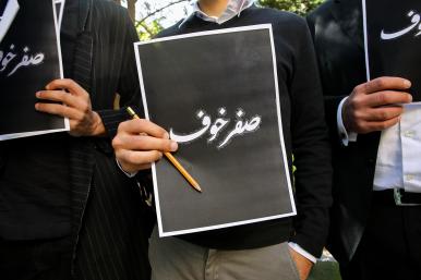 Lebanese protesters hold signs reading "Fearless" in Arabic in response to the assassination of Lokman Slim - source: Reuters