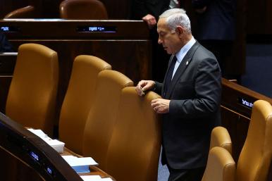 Photo of Israeli prime minister Binyamin Netanyahu standing alone in parliament.