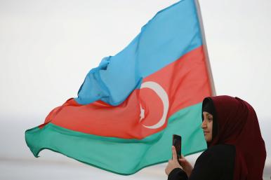 An Azeri woman with an Azerbaijan flag in the Nogorno-Karaback region of Armenia - source: Reuters