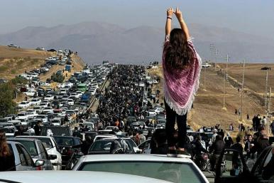 Twitter photo showing an Iranian woman standing on top of a car during a protest against the killing of Mahsa Amini.