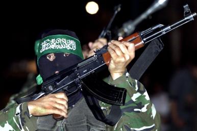 A masked Hamas fighter brandishes a rifle in Gaza - source: Reuters
