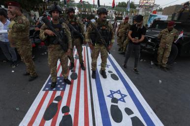 Photo of an October 2023 Iraqi demonstration with footprints covering the Israeli and American flags.