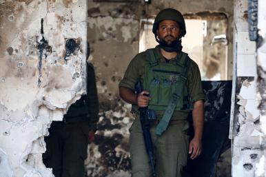Photo of an Israeli soldier in the ruins of a kibbutz following the October 2023 Hamas attack.