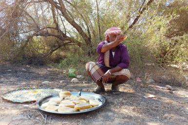 A beekeeper harvests honeycombs and holds part of them in his hand in Hadhramaut, Yemen