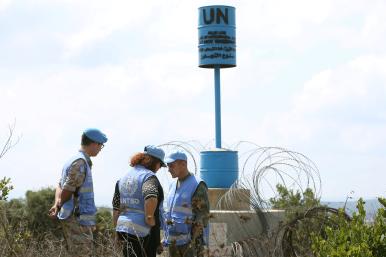 Unarmed UN staff from the United Nations Truce Supervision Organization stand near a Blue Line marker on the Israel-Lebanon borner - source: Reuters