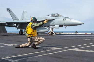 Photo of an F-18 fighter jet launching from a U.S. aircraft carrier.