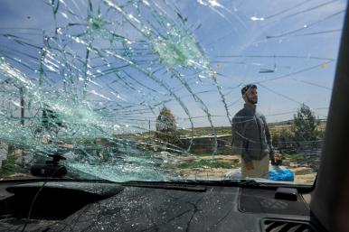 Oscar-winning Palestinian Director Basel Adra checks a damaged car after Israeli settlers' attack in Susiya in the Israeli-occupied West Bank - source: Reuters