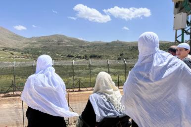 Syrian Druze women look across the Golan border into Israel - source: Reuters