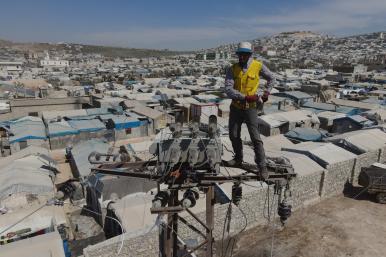 A utility worker repairs electric transmission lines in the Syria's Idlib province - source: Reuters
