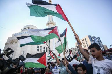 Protesters wave Palestinian flags in Gaza City - source: Reuters